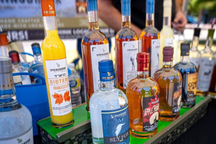 a man standing next to bottles of beer