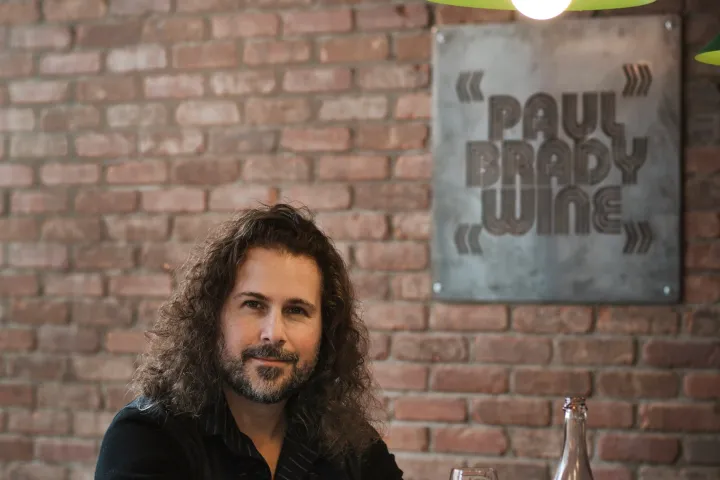 a person sitting at a bar drinking wine