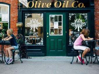 a family sitting outside Olive Oil Co.