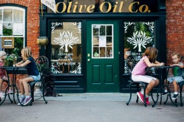 a family sitting outside Olive Oil Co.