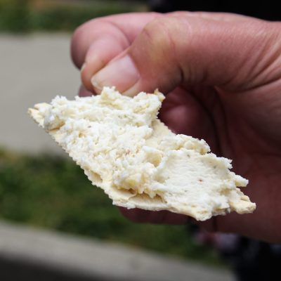 a hand holding a half eaten sandwich