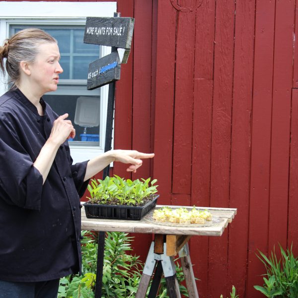 a woman standing in front of produce