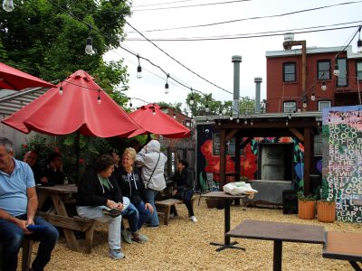 a group of people sitting at tables covered by umbrellas