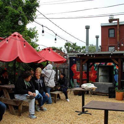 a group of people sitting at a table with an umbrella