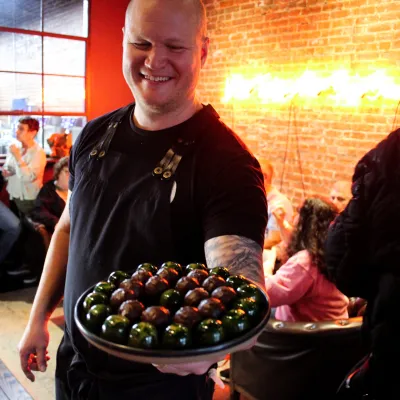 a man and a woman standing in front of a plate of food