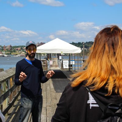 a man and a woman standing in front of a pier