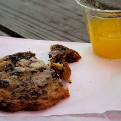 a piece of cake on a plate next to a glass of orange juice